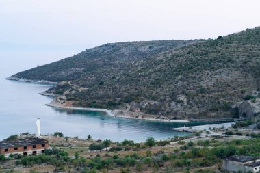 Aydınlatılmış tepeleri olan yüksek dağları olan güzel bir manzara, dağ gölündeki taşlar, yansıma, gün doğumunda sarı güneş ışığı. Seaview ve güzel gün batımı. İHA 'dan fotoğraf. Yatay fotoğraf.