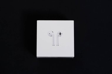 Kyiv, Ukrayna 10 Ağustos 2019 Şarj kutusunda yeni kablosuz kulaklık, karanlık arka plan. Hava podları ulaşılamaz kulaklıklar, şık, koyu bir arka plan. Beyaz kutudaki kulaklıklar izole edilmiş..