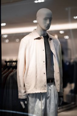 Vitrindeki bir erkek mağazasındaki erkek mankenler sonbahar kış koleksiyonunu gösteriyor. Ayakta duran erkek mankenler gündelik kıyafet koleksiyonu gösterir. Kara Cuma. Dikey.