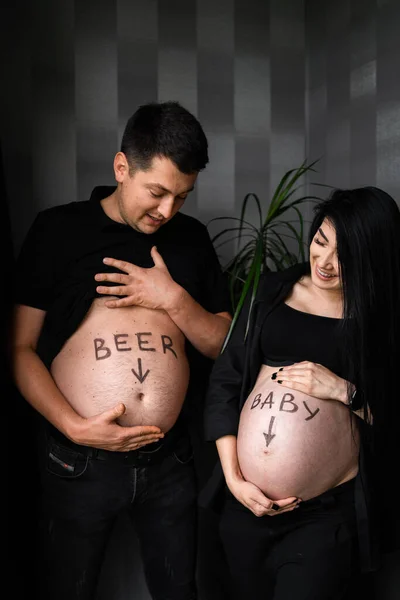 Kreatives Paar mit Zeichnungsbauch erwartet Baby, kreatives Fotoshooting für die Schwangerschaft, glückliche Familie wartet auf Baby Boy. Schwangerschaft, Mutterschaft, Vorbereitung und Erwartungskonzept. — Stockfoto