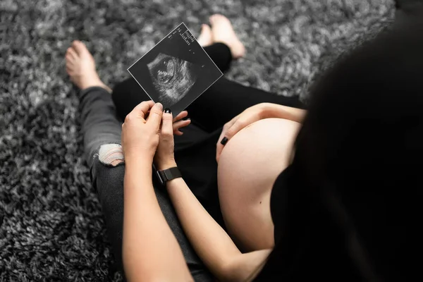 Snímek krásné těhotné ženy a jejího pohledného manžela držícího ultrazvuk. Těhotenství, mateřství, příprava a koncepce očekávání — Stock fotografie