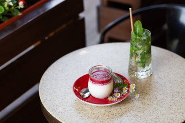 Vanilyalı Panna Cotta ve cam kavanozda jöle. İtalyan tatlı panna cotta ışık masasında.