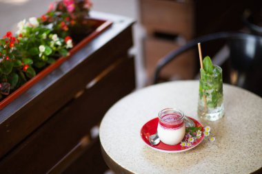 Vanilyalı Panna Cotta ve cam kavanozda jöle. İtalyan tatlı panna cotta ışık masasında.