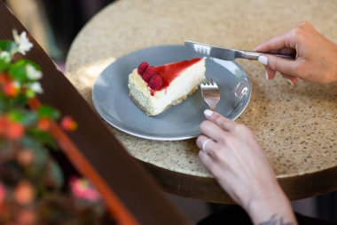 Cheesecake New York mu yoksa reçelli klasik cheesecake mi? Yakından bak. Lezzetli bir kahvaltı. Taş zeminde gri tabakta çocuk oyuncağı..