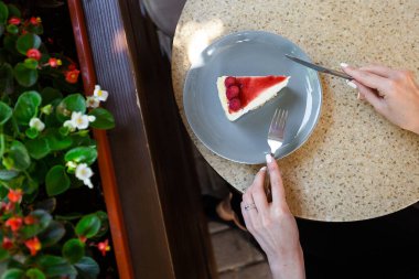 Cheesecake New York mu yoksa reçelli klasik cheesecake mi? Yakından bak. Lezzetli bir kahvaltı. Taş zeminde gri tabakta çocuk oyuncağı..