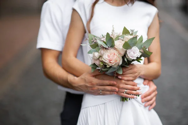 Прекрасная свадебная пара, держащаяся за руки и цветы. Это такой захватывающий момент. Винтажное свадебное платье и мужской костюм. Реклама свадебного салона. Свадебный кортеж — стоковое фото