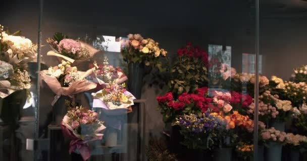 花の配達だ。花屋の店で美しい新鮮な花を閉じます。フラワーショップのコンセプト。花のための冷蔵庫の部屋で別の品種の新鮮な春の花。4k — ストック動画