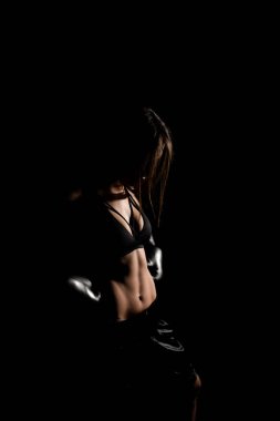 Karanlık ringde kadın boksör eğitimi. Ağır çekim. Siluet. Boks konsepti. Dövüşçü kadın yumruğunu sık. Seyirci video boks maçı. Spor salonunda eldivenlerle gülümseyen kız boksu..
