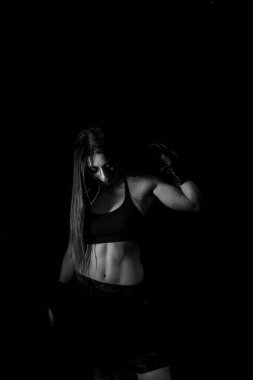 Karanlık ringde kadın boksör eğitimi. Ağır çekim. Siluet. Boks konsepti. Dövüşçü kadın yumruğunu sık. Seyirci video boks maçı. Spor salonunda eldivenlerle gülümseyen kız boksu..