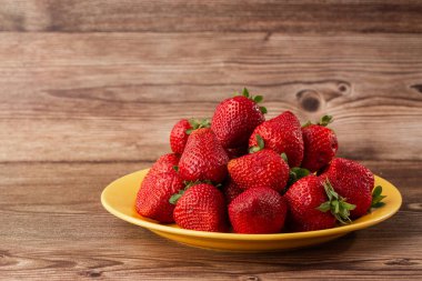 Siyah mermer masadaki kasede taze çilekler. Taze çilekler. Meyve suyu çileği. Meyve çiftliğindeki çilek tarlası. Taze olgun organik çilek beyaz sepetin içinde çilek yatağının yanında kendi böğürtlen tarlanızı seçin..