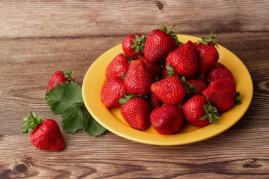 Siyah mermer masadaki kasede taze çilekler. Taze çilekler. Meyve suyu çileği. Meyve çiftliğindeki çilek tarlası. Taze olgun organik çilek beyaz sepetin içinde çilek yatağının yanında kendi böğürtlen tarlanızı seçin..
