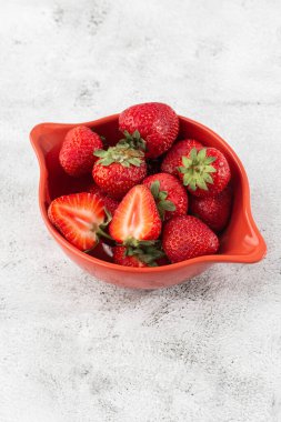 Siyah mermer masadaki kasede taze çilekler. Taze çilekler. Meyve suyu çileği. Meyve çiftliğindeki çilek tarlası. Taze olgun organik çilek beyaz sepetin içinde çilek yatağının yanında kendi böğürtlen tarlanızı seçin..