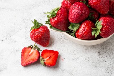 Siyah mermer masadaki kasede taze çilekler. Taze çilekler. Meyve suyu çileği. Meyve çiftliğindeki çilek tarlası. Taze olgun organik çilek beyaz sepetin içinde çilek yatağının yanında kendi böğürtlen tarlanızı seçin..