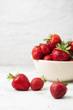 Siyah mermer masadaki kasede taze çilekler. Taze çilekler. Meyve suyu çileği. Meyve çiftliğindeki çilek tarlası. Taze olgun organik çilek beyaz sepetin içinde çilek yatağının yanında kendi böğürtlen tarlanızı seçin..