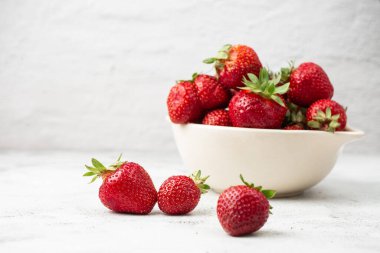 Siyah mermer masadaki kasede taze çilekler. Taze çilekler. Meyve suyu çileği. Meyve çiftliğindeki çilek tarlası. Taze olgun organik çilek beyaz sepetin içinde çilek yatağının yanında kendi böğürtlen tarlanızı seçin..