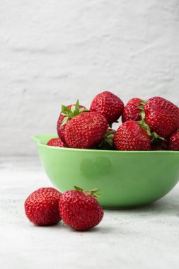 Siyah mermer masadaki kasede taze çilekler. Taze çilekler. Meyve suyu çileği. Meyve çiftliğindeki çilek tarlası. Taze olgun organik çilek beyaz sepetin içinde çilek yatağının yanında kendi böğürtlen tarlanızı seçin..