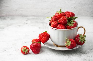 Siyah mermer masadaki kasede taze çilekler. Taze çilekler. Meyve suyu çileği. Meyve çiftliğindeki çilek tarlası. Taze olgun organik çilek beyaz sepetin içinde çilek yatağının yanında kendi böğürtlen tarlanızı seçin..