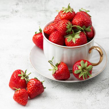 Siyah mermer masadaki kasede taze çilekler. Taze çilekler. Meyve suyu çileği. Meyve çiftliğindeki çilek tarlası. Taze olgun organik çilek beyaz sepetin içinde çilek yatağının yanında kendi böğürtlen tarlanızı seçin..