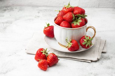 Siyah mermer masadaki kasede taze çilekler. Taze çilekler. Meyve suyu çileği. Meyve çiftliğindeki çilek tarlası. Taze olgun organik çilek beyaz sepetin içinde çilek yatağının yanında kendi böğürtlen tarlanızı seçin..