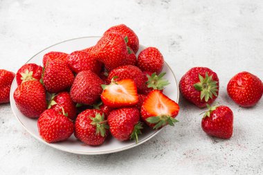Siyah mermer masadaki kasede taze çilekler. Taze çilekler. Meyve suyu çileği. Meyve çiftliğindeki çilek tarlası. Taze olgun organik çilek beyaz sepetin içinde çilek yatağının yanında kendi böğürtlen tarlanızı seçin..