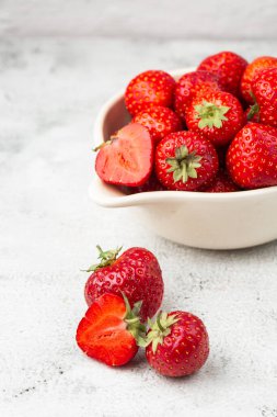 Siyah mermer masadaki kasede taze çilekler. Taze çilekler. Meyve suyu çileği. Meyve çiftliğindeki çilek tarlası. Taze olgun organik çilek beyaz sepetin içinde çilek yatağının yanında kendi böğürtlen tarlanızı seçin..