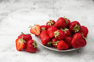 Siyah mermer masadaki kasede taze çilekler. Taze çilekler. Meyve suyu çileği. Meyve çiftliğindeki çilek tarlası. Taze olgun organik çilek beyaz sepetin içinde çilek yatağının yanında kendi böğürtlen tarlanızı seçin..