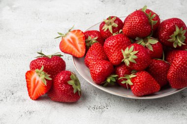 Siyah mermer masadaki kasede taze çilekler. Taze çilekler. Meyve suyu çileği. Meyve çiftliğindeki çilek tarlası. Taze olgun organik çilek beyaz sepetin içinde çilek yatağının yanında kendi böğürtlen tarlanızı seçin..