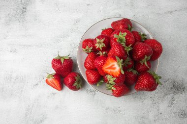 Siyah mermer masadaki kasede taze çilekler. Taze çilekler. Meyve suyu çileği. Meyve çiftliğindeki çilek tarlası. Taze olgun organik çilek beyaz sepetin içinde çilek yatağının yanında kendi böğürtlen tarlanızı seçin..