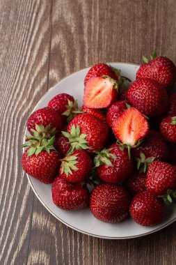 Siyah mermer masadaki kasede taze çilekler. Taze çilekler. Meyve suyu çileği. Meyve çiftliğindeki çilek tarlası. Taze olgun organik çilek beyaz sepetin içinde çilek yatağının yanında kendi böğürtlen tarlanızı seçin..