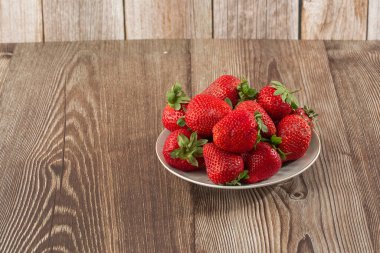 Siyah mermer masadaki kasede taze çilekler. Taze çilekler. Meyve suyu çileği. Meyve çiftliğindeki çilek tarlası. Taze olgun organik çilek beyaz sepetin içinde çilek yatağının yanında kendi böğürtlen tarlanızı seçin..