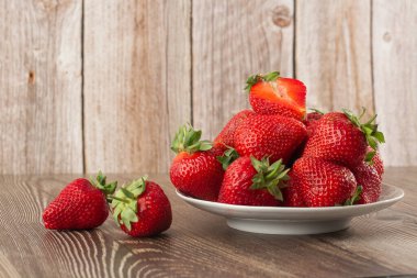 Siyah mermer masadaki kasede taze çilekler. Taze çilekler. Meyve suyu çileği. Meyve çiftliğindeki çilek tarlası. Taze olgun organik çilek beyaz sepetin içinde çilek yatağının yanında kendi böğürtlen tarlanızı seçin..