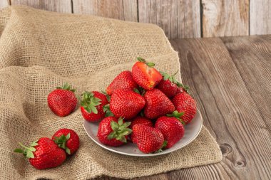 Siyah mermer masadaki kasede taze çilekler. Taze çilekler. Meyve suyu çileği. Meyve çiftliğindeki çilek tarlası. Taze olgun organik çilek beyaz sepetin içinde çilek yatağının yanında kendi böğürtlen tarlanızı seçin..