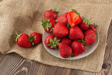 Siyah mermer masadaki kasede taze çilekler. Taze çilekler. Meyve suyu çileği. Meyve çiftliğindeki çilek tarlası. Taze olgun organik çilek beyaz sepetin içinde çilek yatağının yanında kendi böğürtlen tarlanızı seçin..