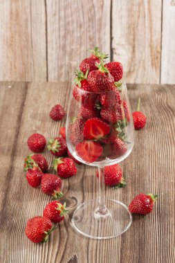 Siyah mermer masadaki kasede taze çilekler. Taze çilekler. Meyve suyu çileği. Meyve çiftliğindeki çilek tarlası. Taze olgun organik çilek beyaz sepetin içinde çilek yatağının yanında kendi böğürtlen tarlanızı seçin..