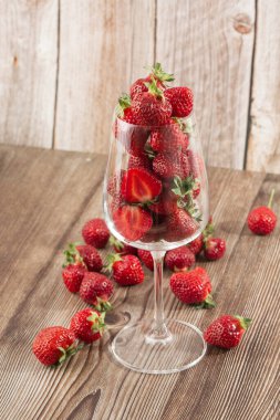 Siyah mermer masadaki kasede taze çilekler. Taze çilekler. Meyve suyu çileği. Meyve çiftliğindeki çilek tarlası. Taze olgun organik çilek beyaz sepetin içinde çilek yatağının yanında kendi böğürtlen tarlanızı seçin..