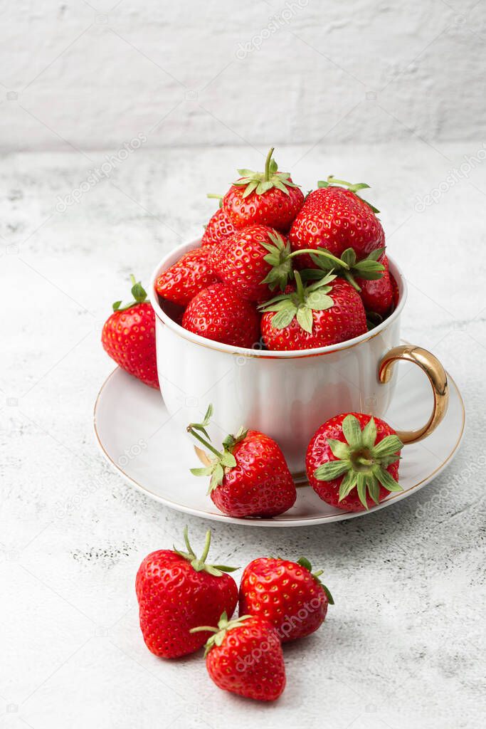 Fresh strawberries in a bowl on marble black table. Fresh nice strawberries. Juice strawberry. Strawberry field on fruit farm. Fresh ripe organic strawberry in white basket next to strawberries bed on pick your own berry plantation.