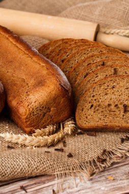 Ev yapımı pişirme. Gri ekmek, un ve süt ile ahşap doğrama tahtasının üzerinde çavdar ekmeği..