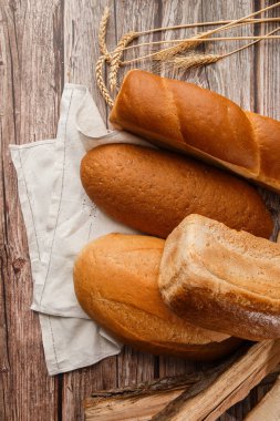 Arka plan olarak farklı taze ekmek türleri, üst görünüm. Fırın. Siyah karatahta zemininde ekmek ve çörekler. Yukardan yakalanan hayat.