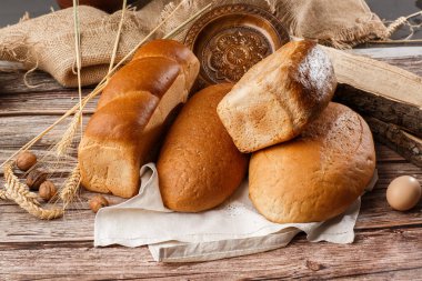 Arka plan olarak farklı taze ekmek türleri, üst görünüm. Fırın. Siyah karatahta zemininde ekmek ve çörekler. Yukardan yakalanan hayat.