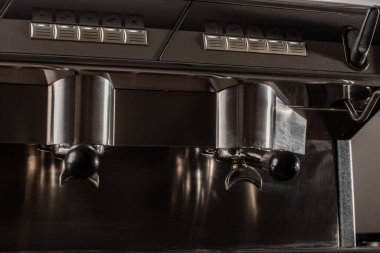 Profesyonel makineden fincana kahve dökülüyor. Barista espresso yapıyor, filtre tutacağı kullanıyor. Taze kahve akıyor. Sabahları kavrulmuş sade kahve içmek..