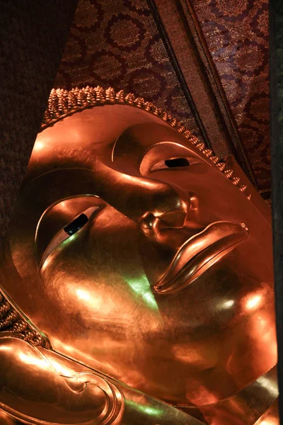 Reclining Buddha gold statue face in Wat Pho, Bangkok