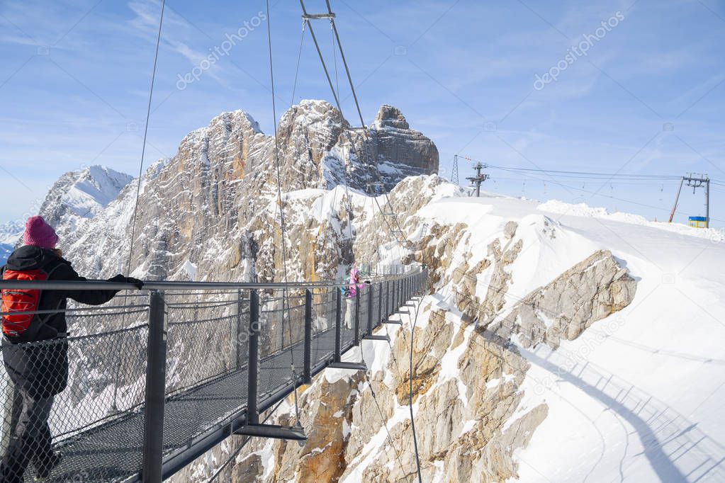 people walking on skywalk rope bridge on Dachstein mountain