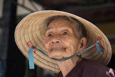 Hoi An, Vietnam, Temmuz 2017: konik şapka giyen yaşlı kadın portresi