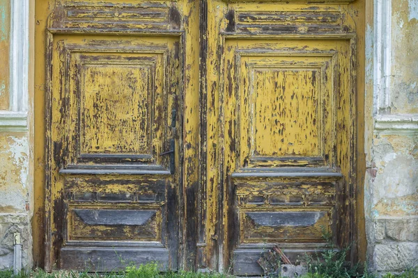 Ξεπερασμένη ξύλινη πόρτα με ξεφλούδισμα κίτρινο χρώμα — Φωτογραφία Αρχείου