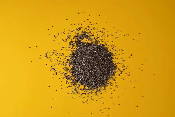 Chia tohumu sarı pastel arka plan, düz yatıyordu görünümü üzerinde bir avuç