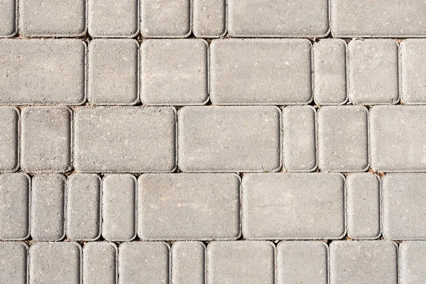 Stone tile background. Grey textured fond. Different sized pavement