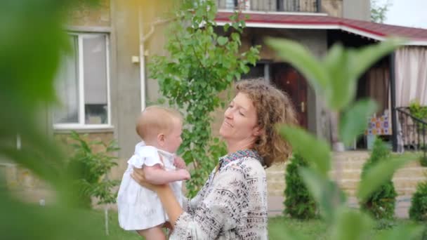 Lächelndes Kleinkind mit Mutter. Lebensanfang Konzept. Geschäftsfrau mit Kind. Baby Mädchen auf den Händen der Mutter. — Stockvideo