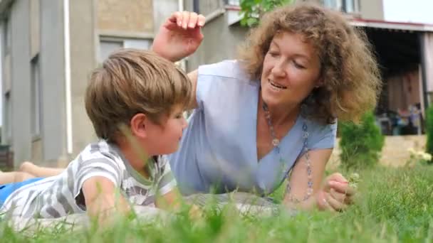 Kolay ebeveynlik kavramı. Mutlu anne ve çocuk çim üzerinde yalan. — Stok video
