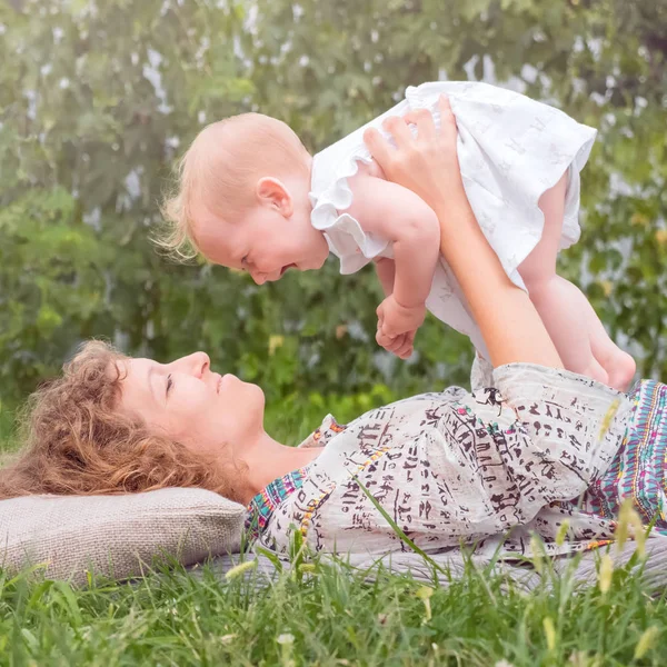 Дівчинка на руках матерів. Усміхнений малюк з мамою. Початок життя концепція. Ділова леді з дитиною . — стокове фото