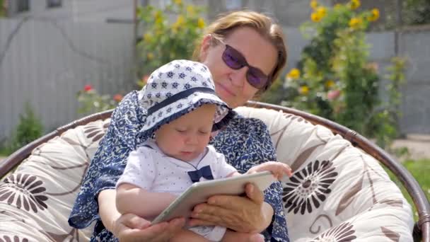 Peuter met oma houdt van Tablet PC. Gelukkige familie concept. Grootmoeder met kleindochter. — Stockvideo